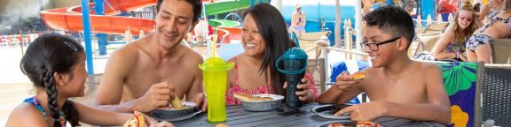 Family of Four smiling and enjoying food.