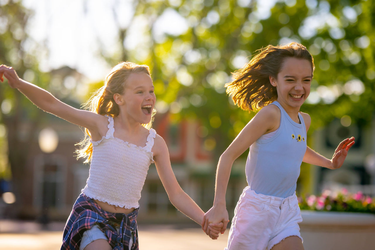 Two girls running through the park
