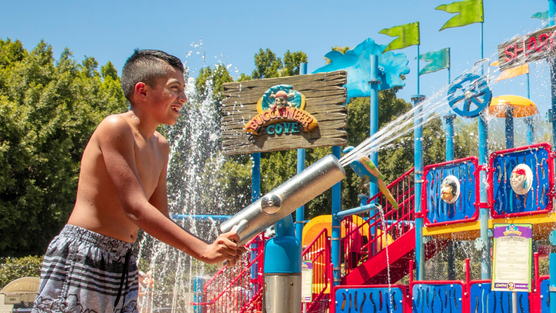 A boy in a splash area inside Buccaneer Cove at Castle Park