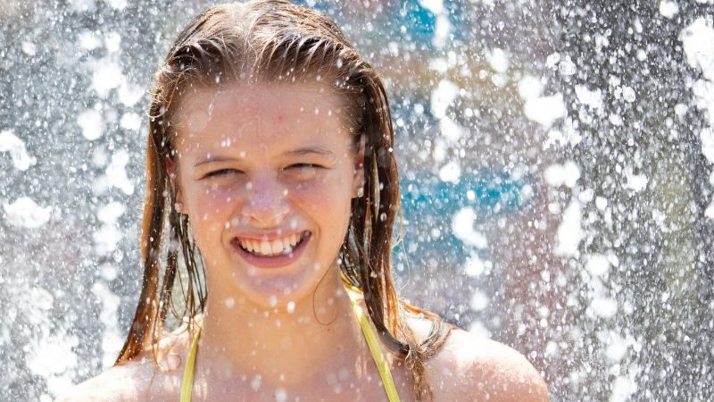 A girl smiling in a splash area inside Buccaneer Cove at Castle Park