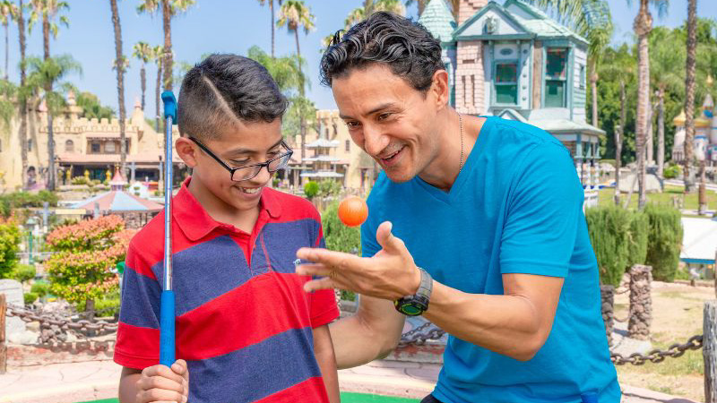 Boy and Father playing mini golf at Castle Park